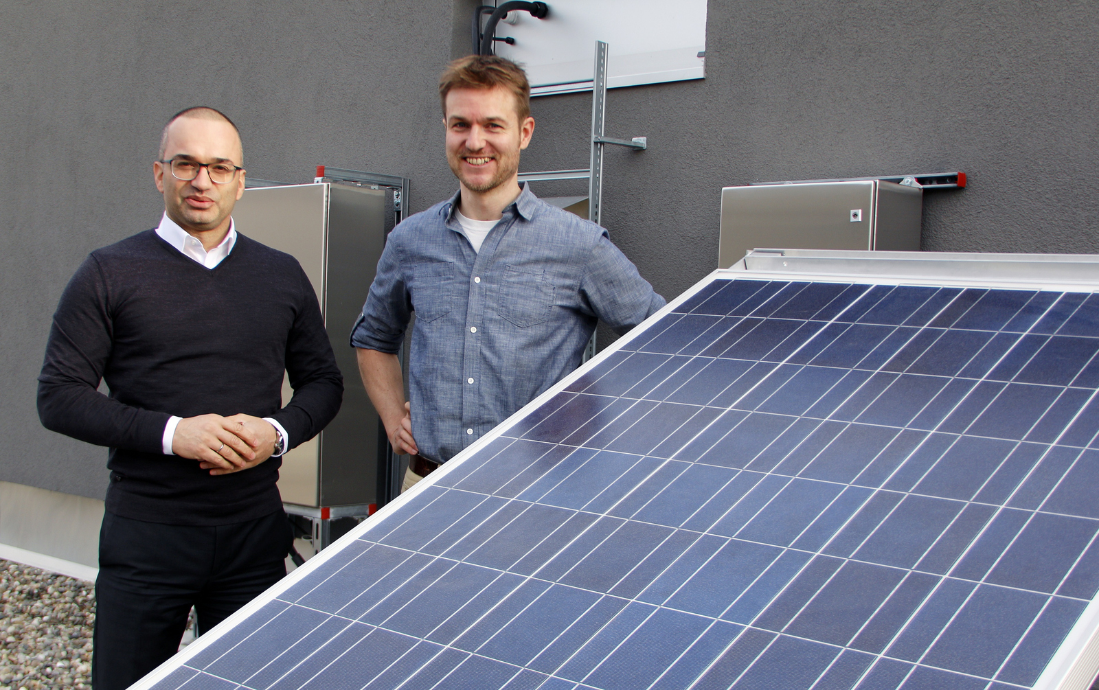 Bülent Tarkan (links) und Tobias Braun (rechts) stehen neben der Photovoltaik-Anlage auf dem Dach der RIZ Energie.