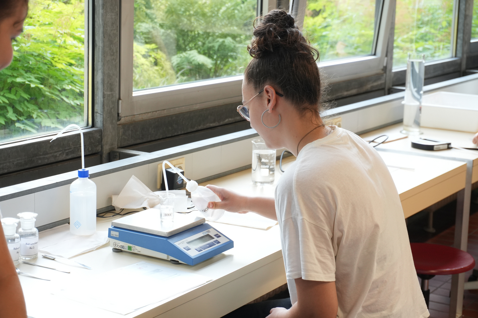2025-07-18 PM Besuch Klosterschulen Mikroplastik Ein Mädchen untersucht eine Wasserprobe mit Mikroplastik