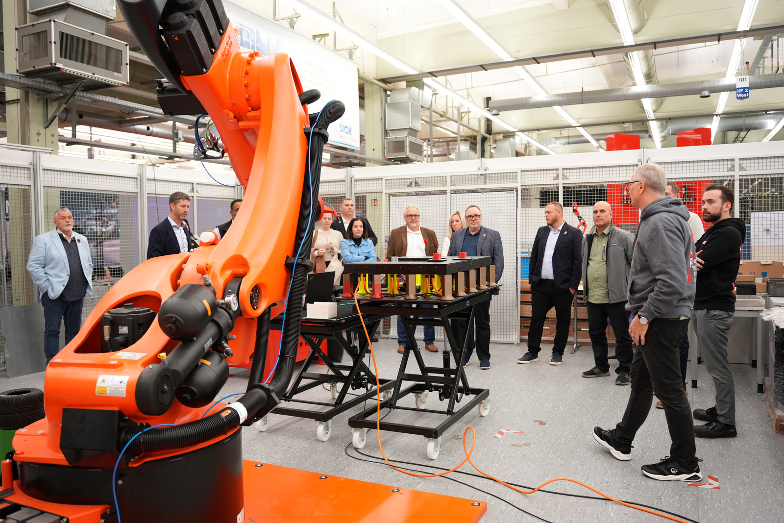 Menschen stehen um einen Industrieroboter herum