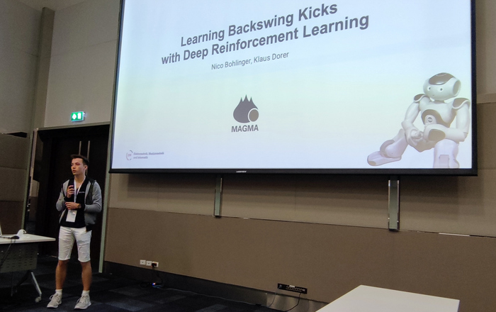 Nico Bohlinger steht bei seinem Vortrag in der Scientific Challenge vor einer großen Leinwand.