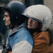 Zwei junge Leute mit Helm die auf einem Scooter fahren, da auf dem Ausschnitt aber nicht zu sehen ist