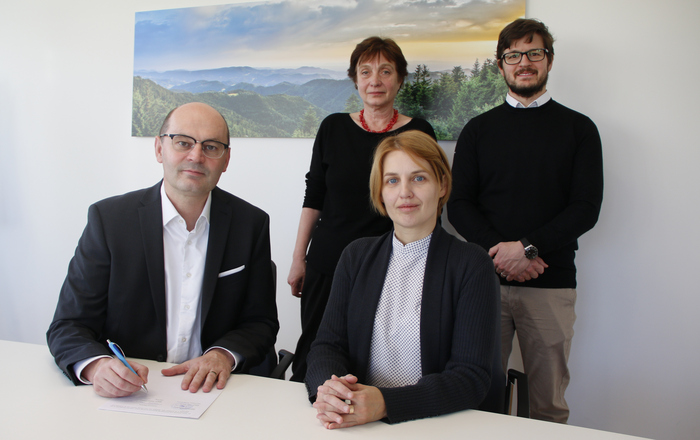 Stephan Trahasch und Oksana Lozovenko sitzen an einem Tisch, Evgenia Sikorski und Alexander Burdumy stehen hinter den beiden.