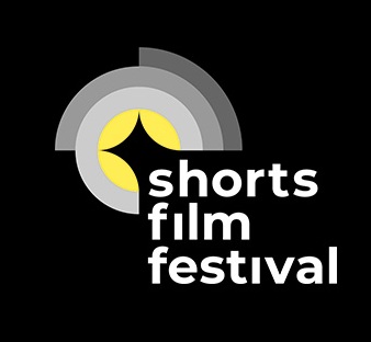 Logo des shorts film festivals in den Fraben scharz weiß grau und gelb deutet durch mehre ineinander liegende Halbkreise und Kreise ein Kameralinse an in deren unterer  rechter Ecke untereinander die Wort shorts film festival stehen 