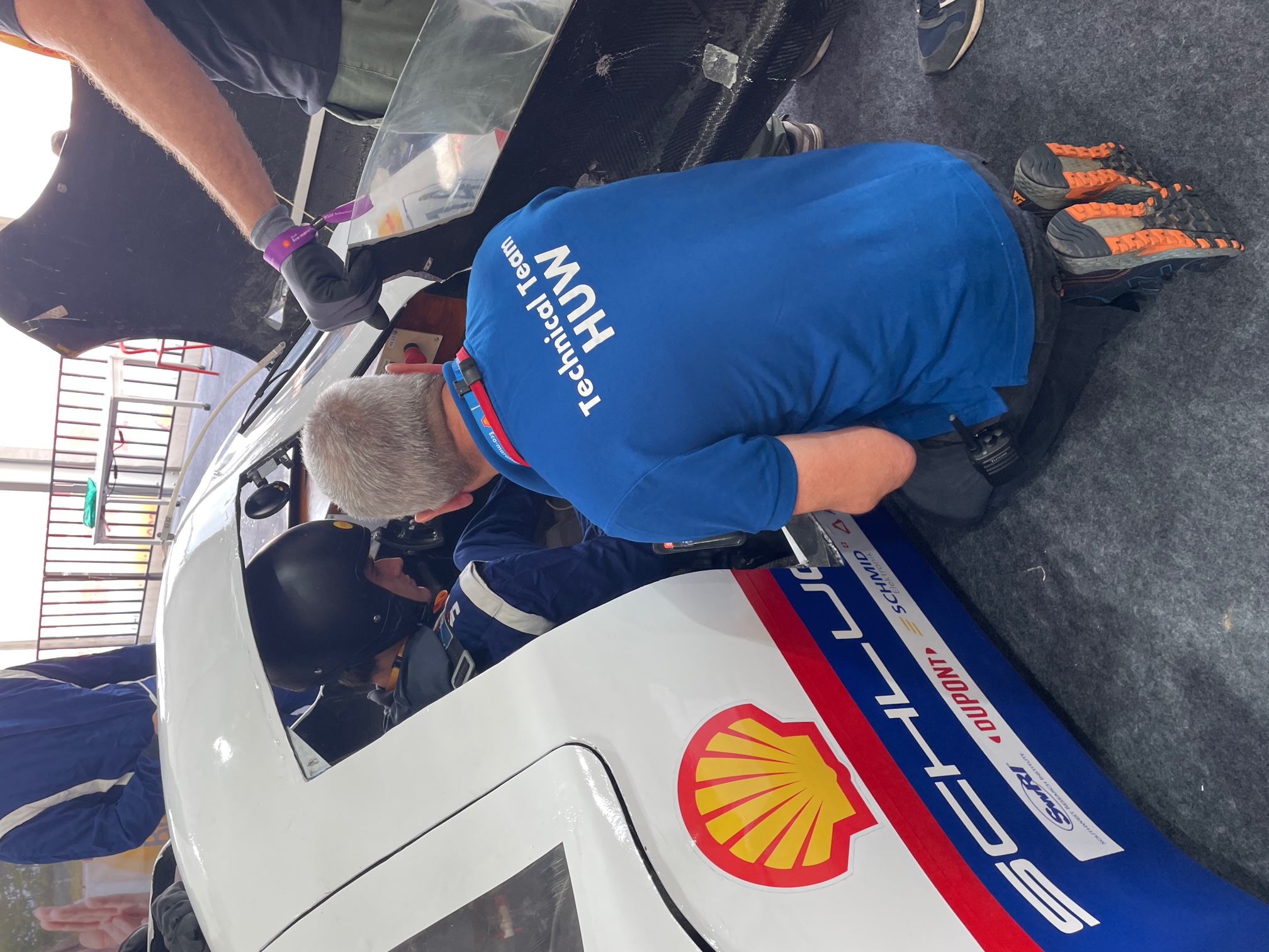 Huw vom Technical Team kniet neben der Fahrzeugtur 