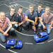 Gruppenfoto mit zwei Modellfahrzeugen auf dem Parcours
